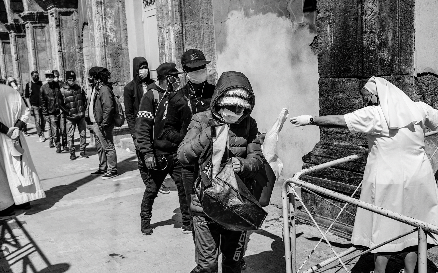 People standing in queue to receive a warm meal. Many of the city’s canteen and dormitories for the poor and the homeless were shut down during the emergency leaving many people even more vulnerable 